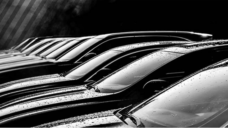 A black and white photo of a row of car windshields.
