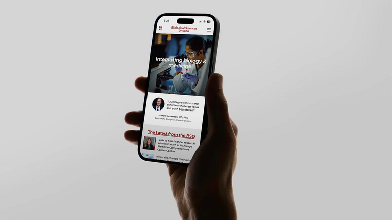 Person holding an iPhone viewing the homepage of the University of Chicago's Biological Sciences Division website, designed by IfThen.